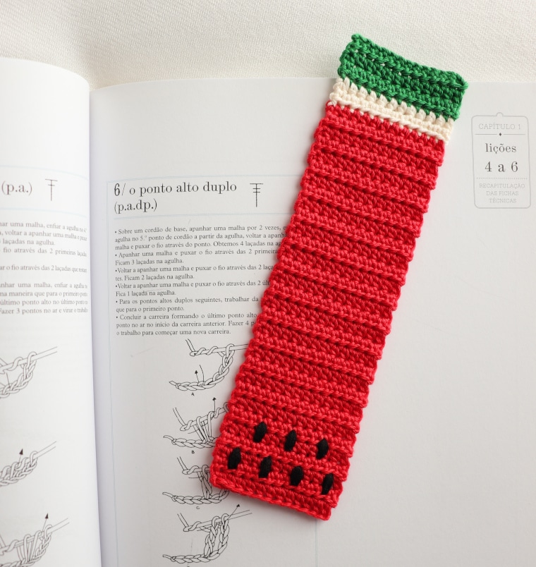 The Watermelon Bookmark of the Crochet Tropical Bookmark Set on a book