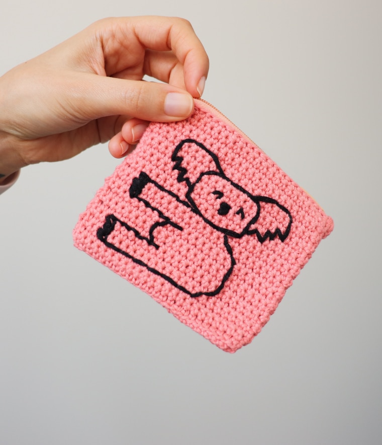Person holding the Crochet Koala Coin Purse by one of the top corners