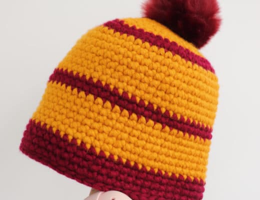 Person with hand inside the Crochet Cross Stitch Beanie against white surface