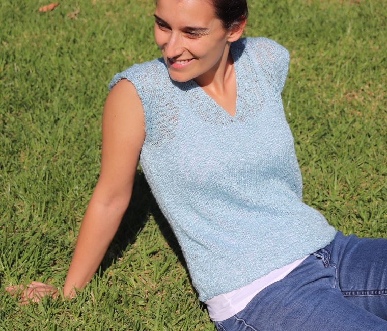 Susana from Fluffy Stitches wearing the Knit Blue Sky Tee sitting on green grass on a summer day