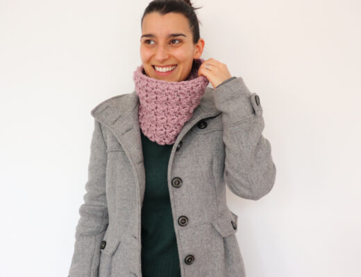Susana from Fluffy Stitches wearing dusty pink crochet easy textured cowl against a white background